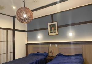 1 dormitorio con 2 camas y lámpara de araña en Good Stay Mizuho, en Usa