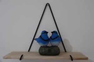 dos pájaros azules sentados en un estante de madera en Timeless Allure near Ringwood, en Heathmont