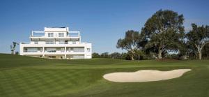 Blick auf ein Golfgrün mit einem Gebäude im Hintergrund in der Unterkunft Sotogrande San Roque Cádiz in San Roque