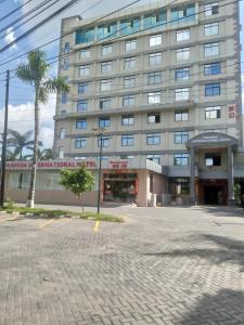 um grande edifício com uma palmeira em frente em FASHION INTERNATIONAL HOTEL em Dar es Salaam