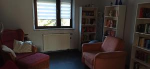 a living room with a couch and a chair and a window at Ferienwohnung Marie in Nohfelden