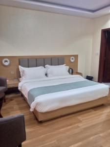 um quarto com uma cama grande e um cobertor azul em FASHION INTERNATIONAL HOTEL em Dar es Salaam