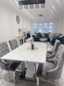 a living room with a large white table and chairs at Home near London Heathrow, Slough,Windsor,Legoland in Colnbrook
