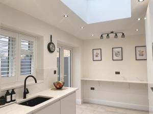 a kitchen with a sink and a clock on the ceiling at Home near London Heathrow, Slough,Windsor,Legoland in Colnbrook