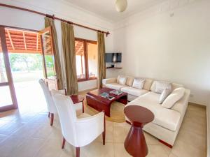 a living room with a couch and chairs and a table at Vipingo Ridge limited in Kilifi