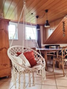 a hanging chair with pillows in a living room at Ferienwohnung am Lutherweg 1521 in Breitenbach am Herzberg