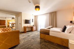 Habitación de hotel con 2 camas y sofá en Pokoje z wyżywieniem i krytym basenem w Amber Park Spa en Niechorze