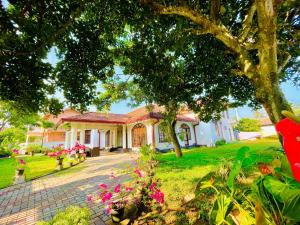 uma casa com flores cor-de-rosa em frente em Grand Villa Negombo em Negombo