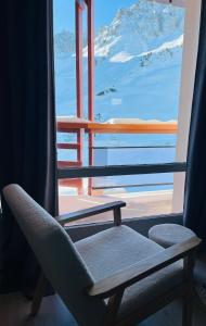 a chair sitting in front of a window with a view at Résidence Bero Bisto in La Mongie