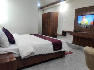 a bedroom with a bed and a flat screen tv at Hotel HV in Nāhan