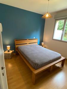 1 dormitorio con 1 cama con pared azul en lemarinel, en Barneville-Carteret