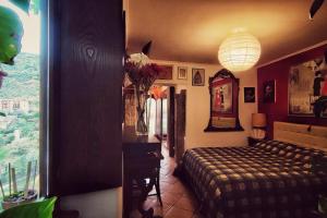 a bedroom with a bed and a table and a window at La casa nel Borgo in San Gregorio da Sassola