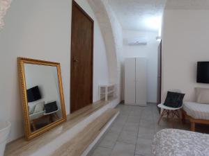 ジュルディニャーノにあるGli Archi Country Homeの鏡、ベッド、ソファが備わる客室です。
