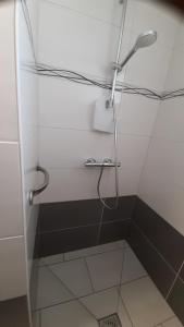 a shower with a shower head in a bathroom at Le Nid de Pie in Le Russey
