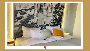 uma cama com almofadas brancas e um quadro na parede em Berghupferl-Alm - do legst di nieda em Flintsbach am Inn