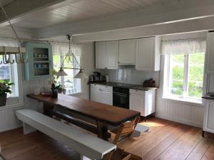 eine Küche mit einem Holztisch und weißen Schränken in der Unterkunft Rodal Lodge in Valsøybotn