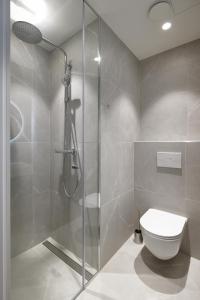 W łazience znajduje się toaleta i przeszklony prysznic. w obiekcie Stylish Volta Quarter Studio - Keyless check-in w Tallinnie