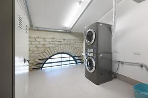pralka i suszarka w pokoju z ceglaną ścianą w obiekcie Stylish Volta Quarter Studio - Keyless check-in w Tallinnie