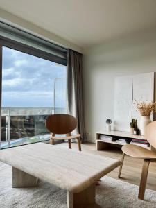 ein Wohnzimmer mit einem Tisch und einem großen Fenster in der Unterkunft Dune sur mer in Bredene