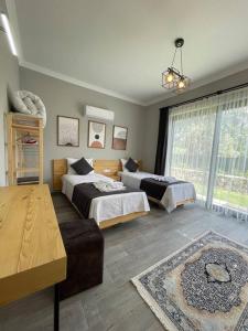 a bedroom with two beds and a large window at Villa Örencik in Fethiye