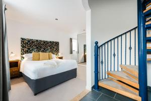 a bedroom with a bed and a staircase at Mannings Hotel in Truro