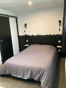 a bedroom with a bed with a black headboard at Studio in Élincourt