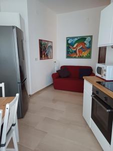 eine Küche und ein Wohnzimmer mit einem roten Sofa in der Unterkunft RQ Apartments in Bari