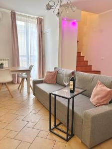 soggiorno con divano e tavolo con bottiglia di vino di RESIDENCE VIOLA a Foggia