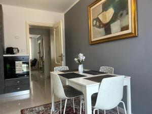 a dining room with a white table and chairs at San Zeno Apartment in Verona
