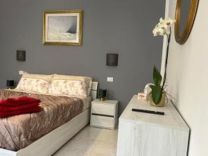 - une chambre avec un lit et une table ornée d'un vase de fleurs dans l'établissement San Zeno Apartment, à Vérone