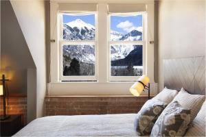 a bedroom with a window with a mountain view at Ajax Loft apts in Telluride