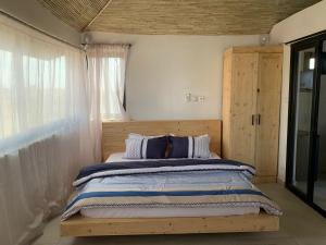 1 dormitorio con 1 cama grande y ventana en Résidence Kali en Guediawaye