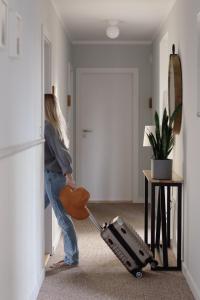 Uma mulher está a puxar um aspirador numa sala. em Busola House em Stegna