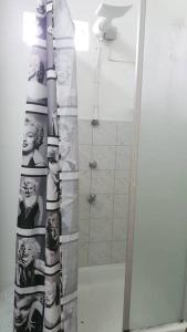 a bathroom with a shower curtain with a picture of people at Superb one bedroom apartment in Grand-Baie