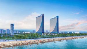 a group of buildings on a beach with people in the water at 0rbi City Luxury Suites in Batumi