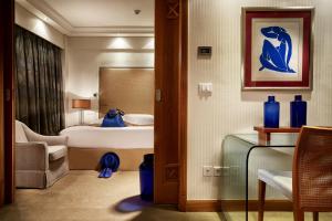a hotel room with a bedroom with a bed at Rodos Park in Rhodes Town
