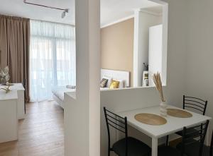 a white room with a table and chairs and a bedroom at Miami Apartments in St. Julianʼs