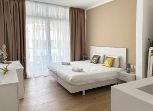 a bedroom with a white bed and a large window at Miami Apartments in St. Julianʼs