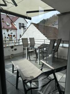 eine Gruppe Stühle und ein Tisch auf dem Balkon in der Unterkunft Cube - Ferienhaus mit Garten und Terrasse in Eberbach in Eberbach