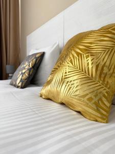 a bed with two yellow pillows on top of it at Miami Apartments in St. Julianʼs