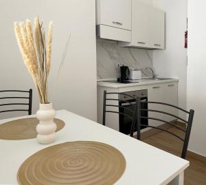 a kitchen with a table with a vase on it at Miami Apartments in St. Julianʼs