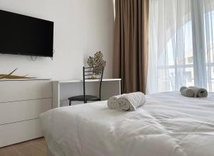 a bedroom with a white bed with towels on it at Miami Apartments in St. Julianʼs