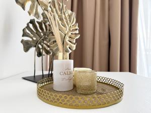 a gold tray with a bottle and a candle at Miami Apartments in St. Julianʼs