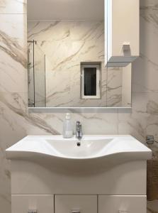 a bathroom with a white sink and a mirror at Miami Apartments in St. Julianʼs