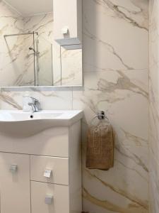 a white bathroom with a sink and a mirror at Miami Apartments in St Julian's