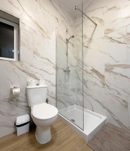 a bathroom with a toilet and a glass shower at Miami Apartments in St. Julianʼs