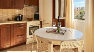 ピタゴリオにあるAgora Apartmentのキッチン(白いテーブル、ワイングラス付)