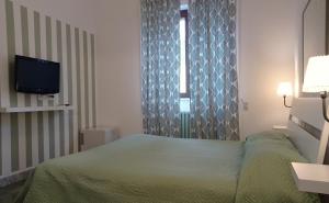 sypialnia z zielonym łóżkiem i oknem w obiekcie Gli Archi Country Home w mieście Giurdignano