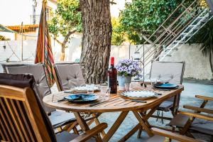 una mesa de madera con sillas y una botella de vino en J&K HOUSE SUITES, en Aghia Marina