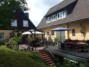 Casa con patio con mesa y sombrilla en Gästehaus HarzGlück en Braunlage